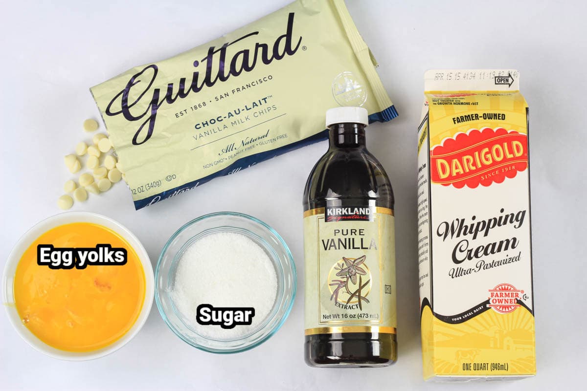 Ingredients for White Chocolate Creme Brulee, including white chocolate chips, egg yolks, sugar, vanilla, and whipping cream.