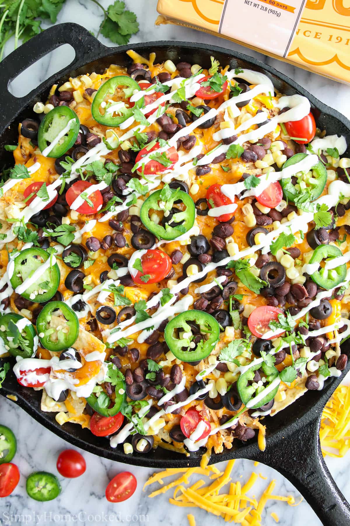 Loaded Chicken Nachos in a cast iron skillet.