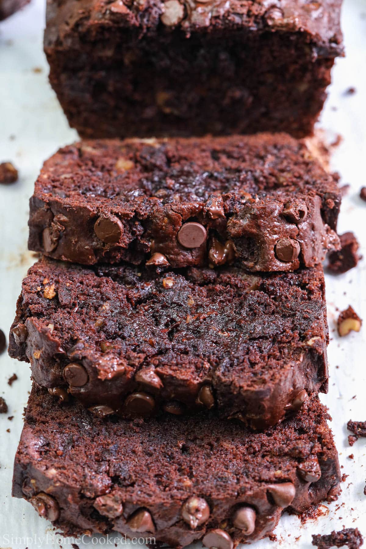 For the richest and most decadent Double Chocolate Banana Bread, you have to try this recipe. It's so moist and chocolaty, you won't be able to wait until dessert to try a slice. #bananbreadslice #doublechocolatebananabreadslice #chocolatebananabreadslice #doublechocolatebananawalnutbreaddessert Slices of Double Chocolate Banana Bread laying on each other