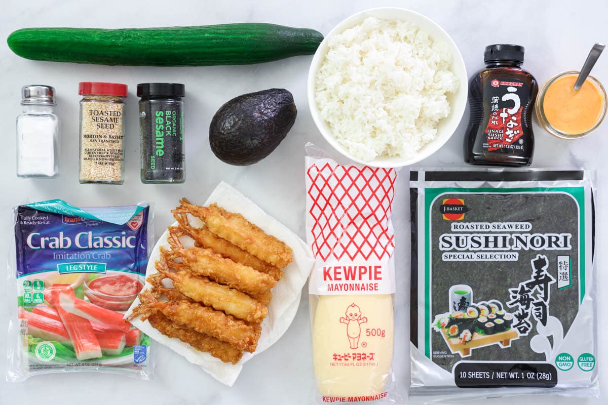 Ingredients for Dynamite Roll: cucumber, avocado, toasted and black sesame seeds, salt, sushi rice, sushi nori, imitation crab, shrimp tempura, unagi sauce, spicy mayo, and Japanese mayo.