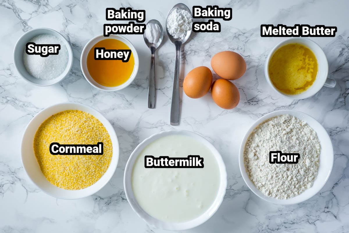 Ingredients for Buttermilk Cornbread: cornmeal, buttermilk, flour, butter, honey, sugar, baking powder, baking soda, and eggs.
