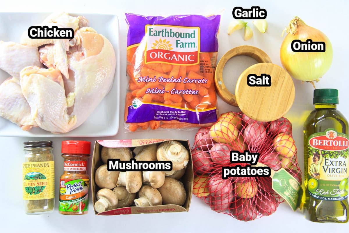 Ingredients for One Pan Chicken and Potatoes: chicken, carrots, garlic, onion, potatoes, mushrooms, Cajun seasoning, cumin, salt, and oil.