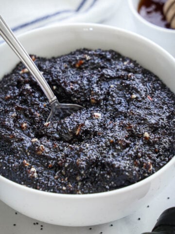 Bowl of Poppy Seed Filling in a white bowl with a spoon.