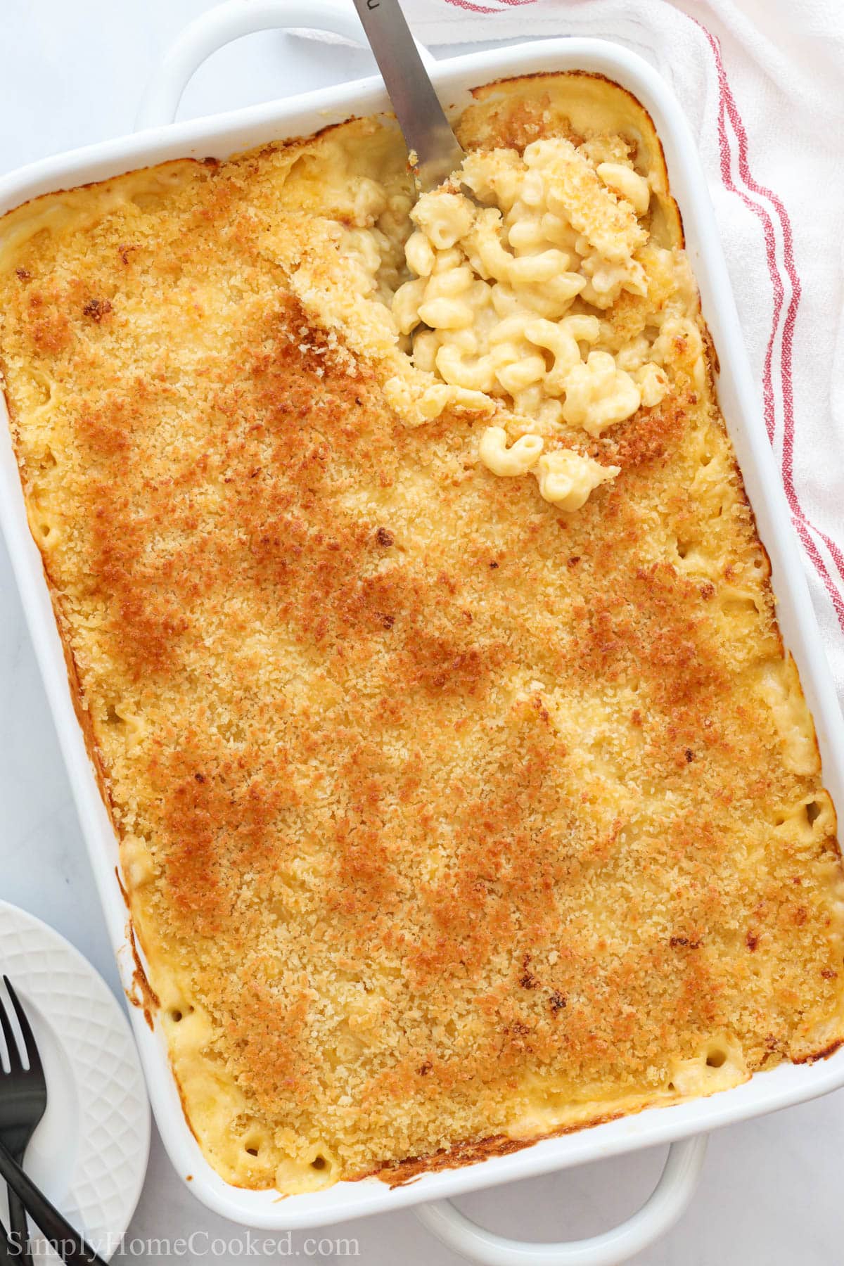 Baking dish of Mac and Cheese  with a spoonful being lifted out.
