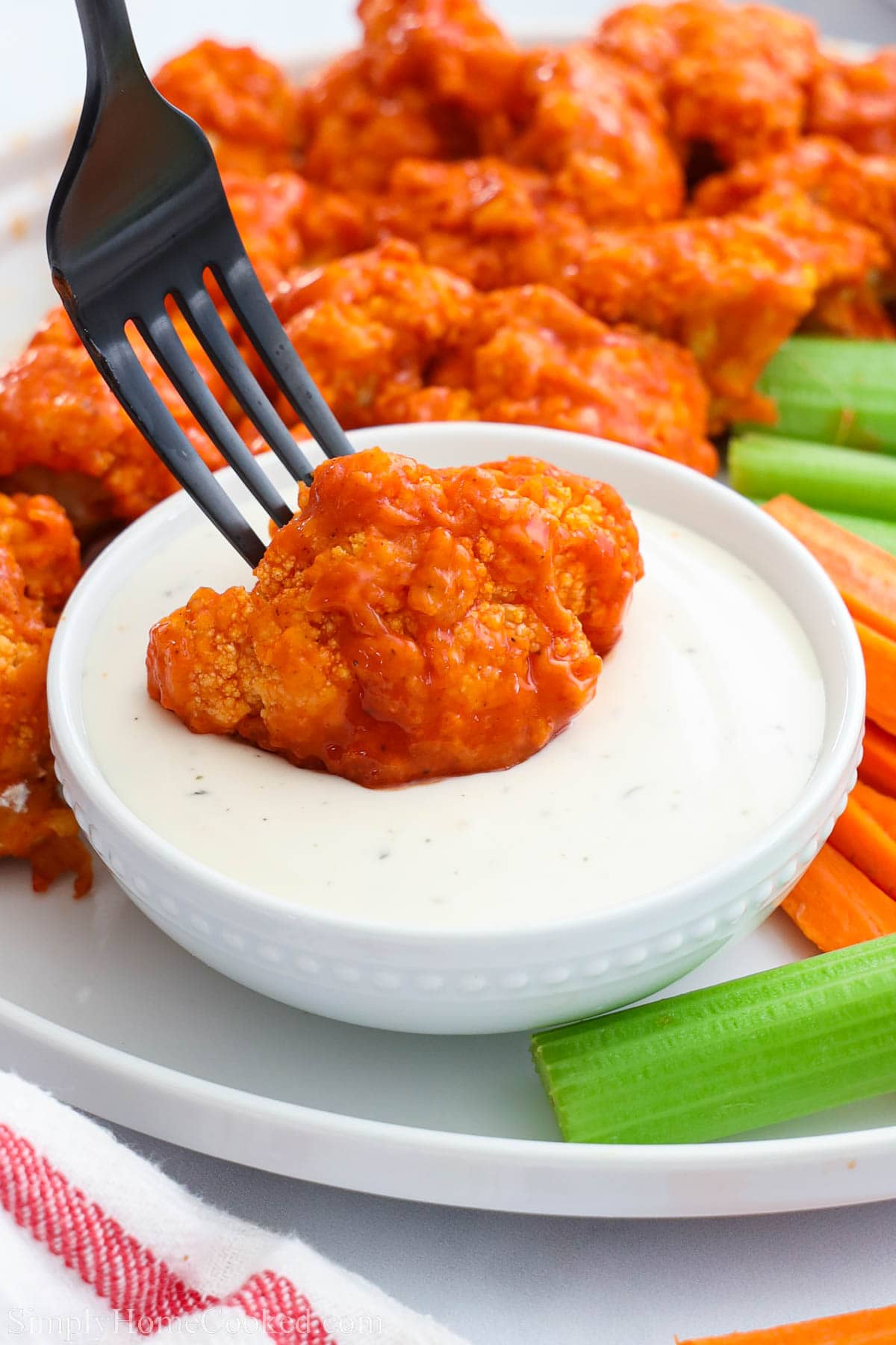 Dipping Air Fryer Buffalo Cauliflower into ranch dressing.