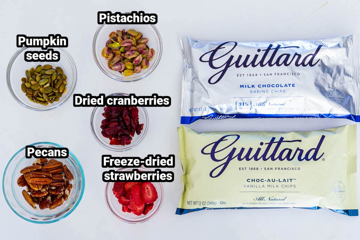 Fine quality chocolate, toasted nuts, and dried fruit make the perfect holiday chocolate bark. It's an easy no-bake dessert perfect for holiday potlucks. #chocolatebark #nobake #chocolatedessert #nobakedessert #quickdessert #easydessert Chocolate Bark ingredients: white and milk chocolate, pumpkin seeds, dried cranberries, pistachios, pecans, freeze-dried strawberries.