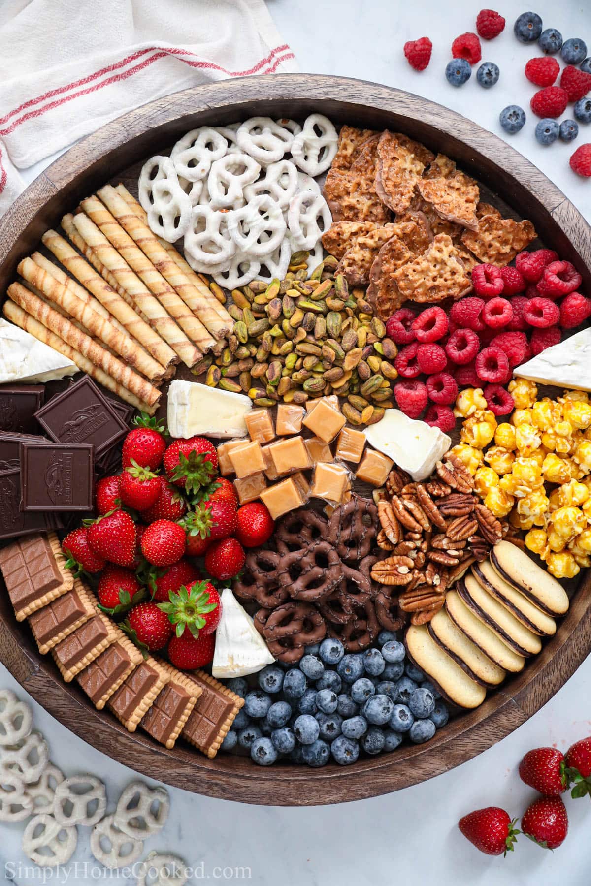 Dessert Charcuterie Board with berries and pretzels nearby