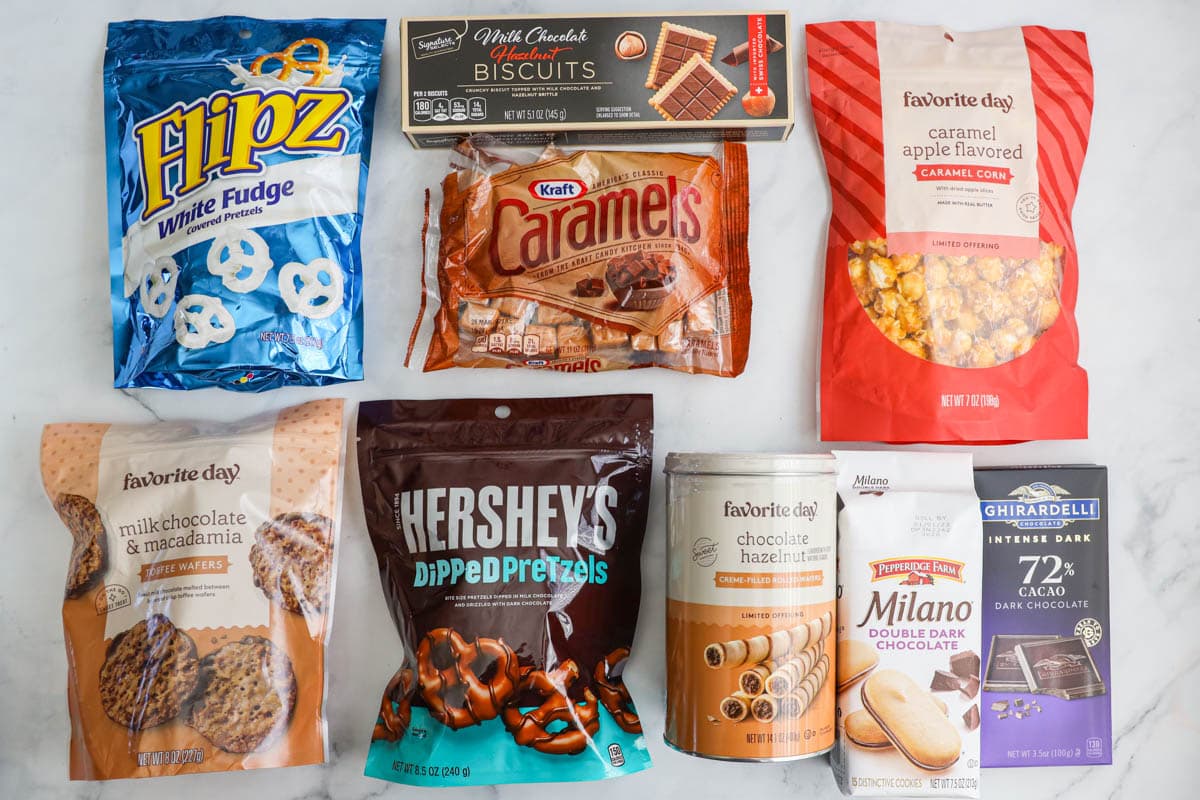Ingredients for Dessert Charcuterie Board: popcorn, pretzels, cookie wafers, wafer rolls, Milano cookies, chocolate, caramels, and biscuits.