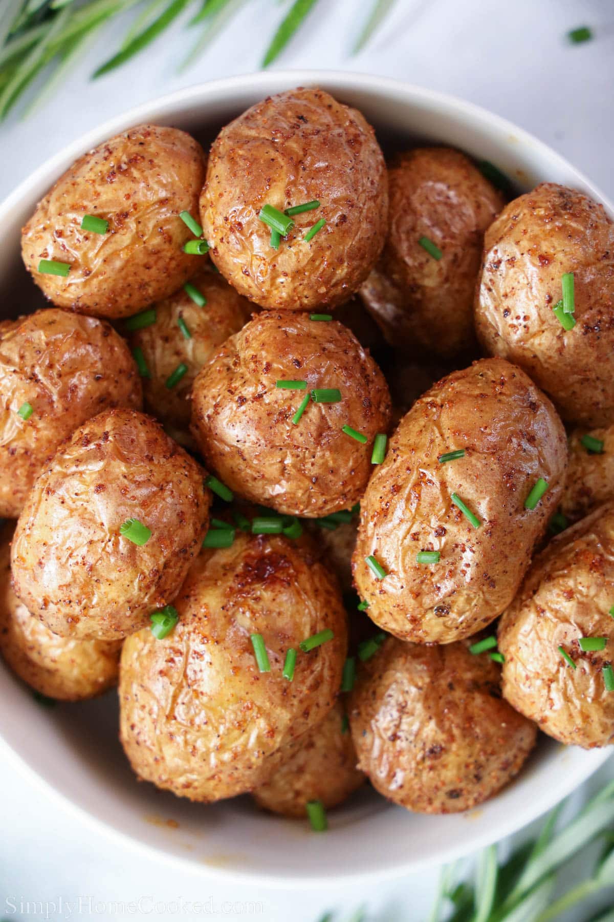 Bowl of Crispy Air Fryer Potatoes garnished with chives.