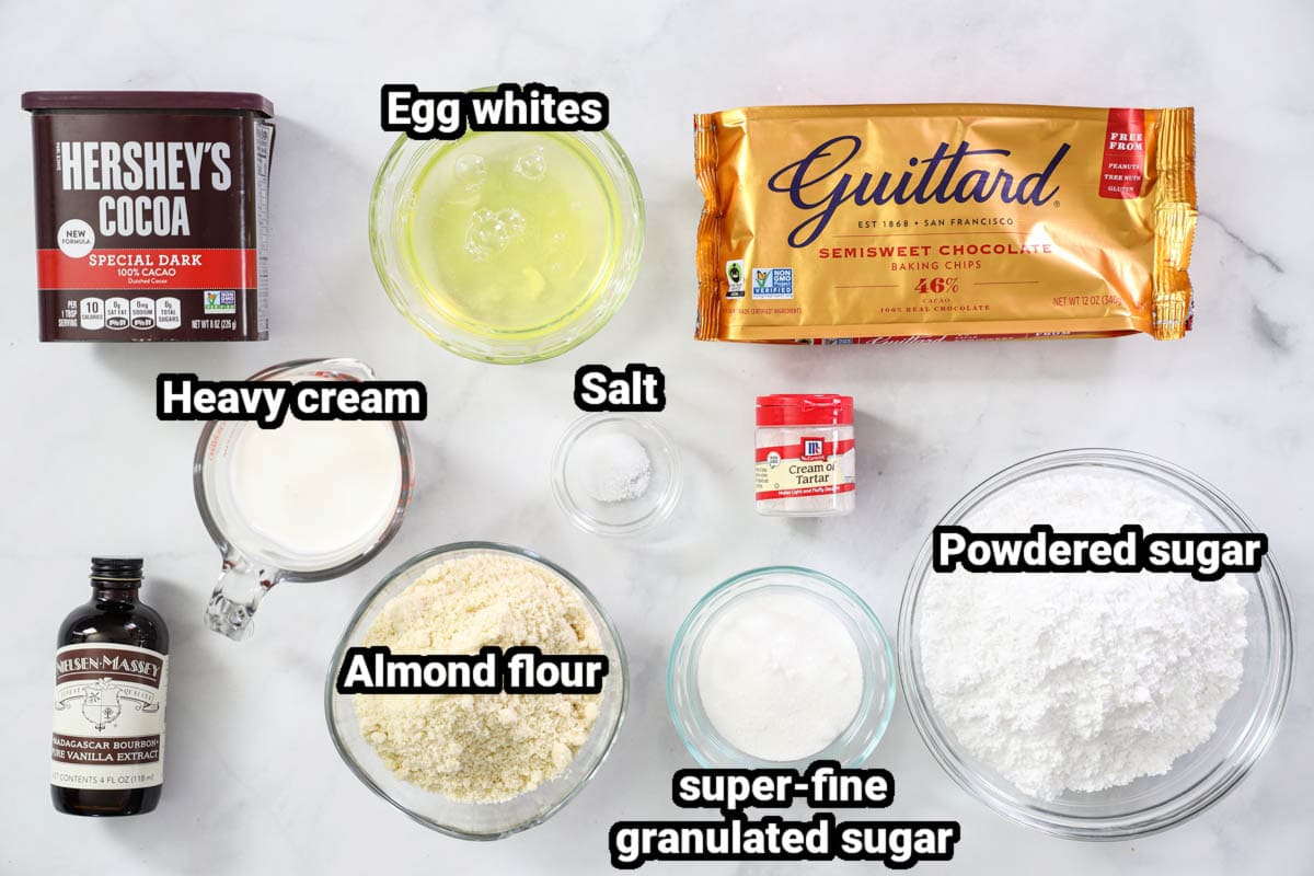 Ingredients for Chocolate Macarons: cocoa powder, egg whites, chocolate chips, heavy cream, salt, cream of tartar, almond flour, vanilla extract, super fine granulated sugar, and powdered sugar.