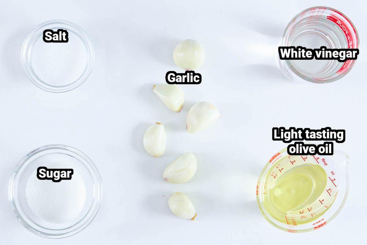 Ingredients for Roasted Eggplant Salad dressing: white vinegar, olive oil, garlic cloves, salt, and sugar.