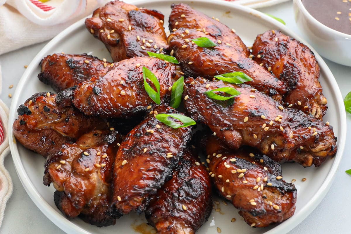 Plate of Teriyaki Chicken Wings garnished with green onion and sesame seeds.