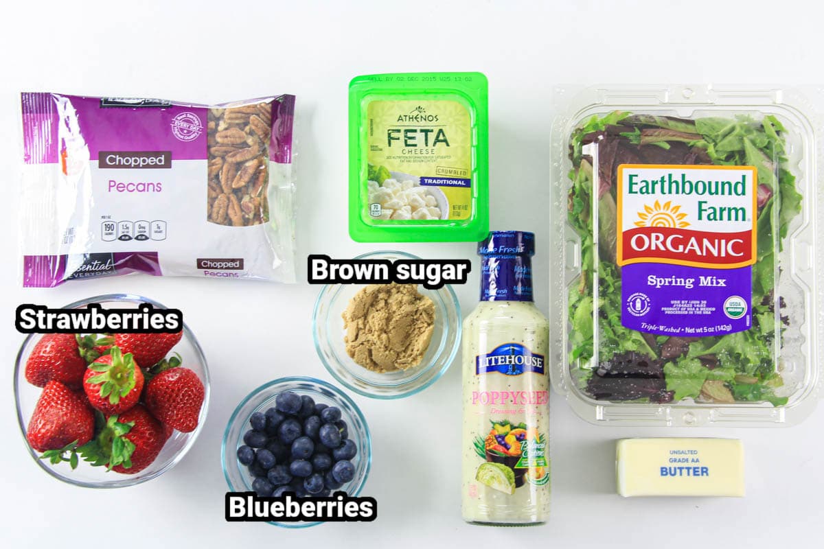 Ingredients for Strawberry Feta Spinach Salad: spring mix, feta cheese, pecans, strawberries, blueberries, brown sugar, butter, and poppyseed dressing.