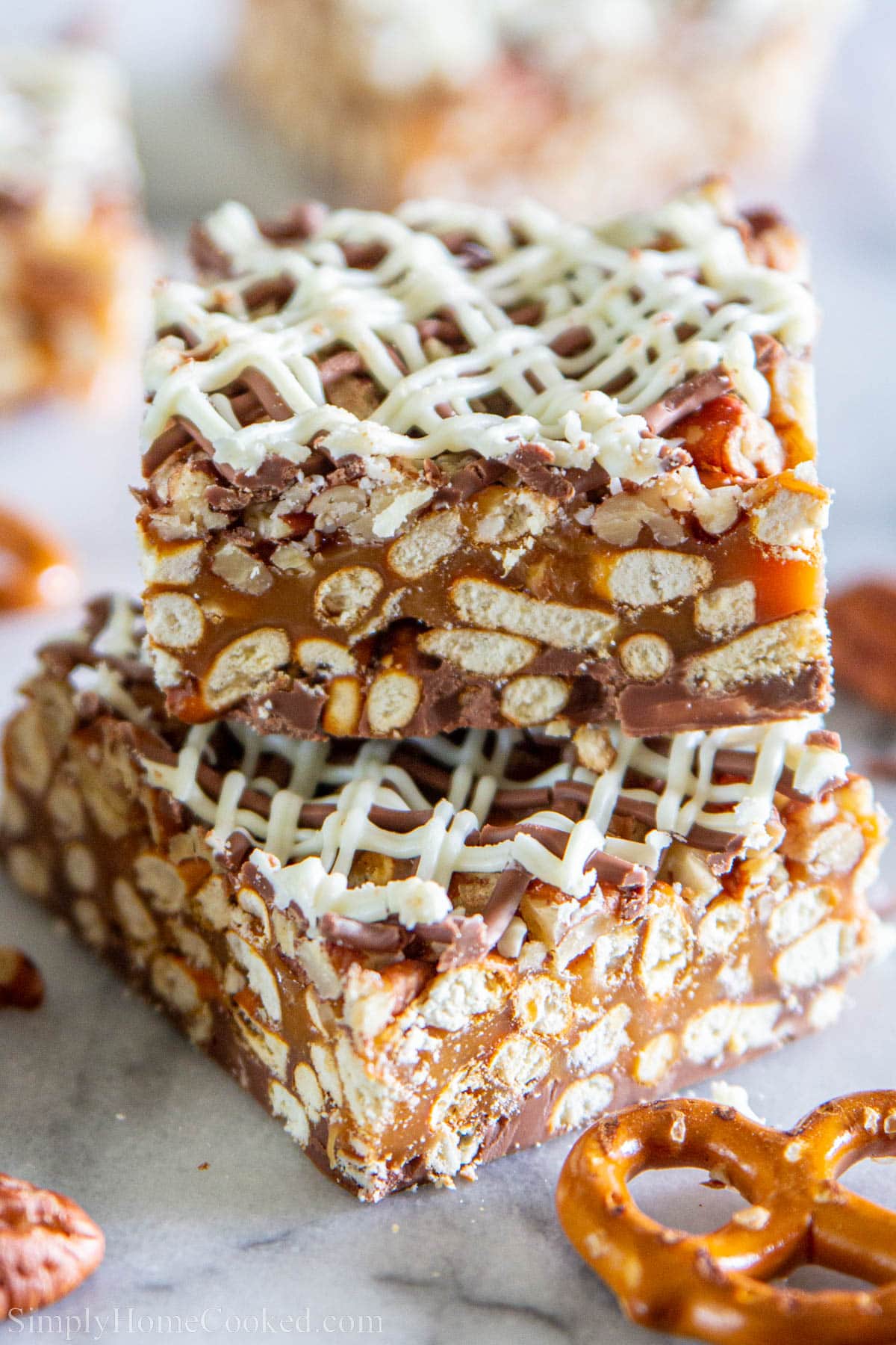 Chocolate Caramel Pretzels Bars with only 4 ingredients are a perfect easy and delicious dessert. Check out our recipe for this salty but sweet treat everyone loves. #caramel #caramelbars #chocolatebars #nobakebars #pretzelbars Chocolate Caramel Pretzel Bars stacked on top of each other.