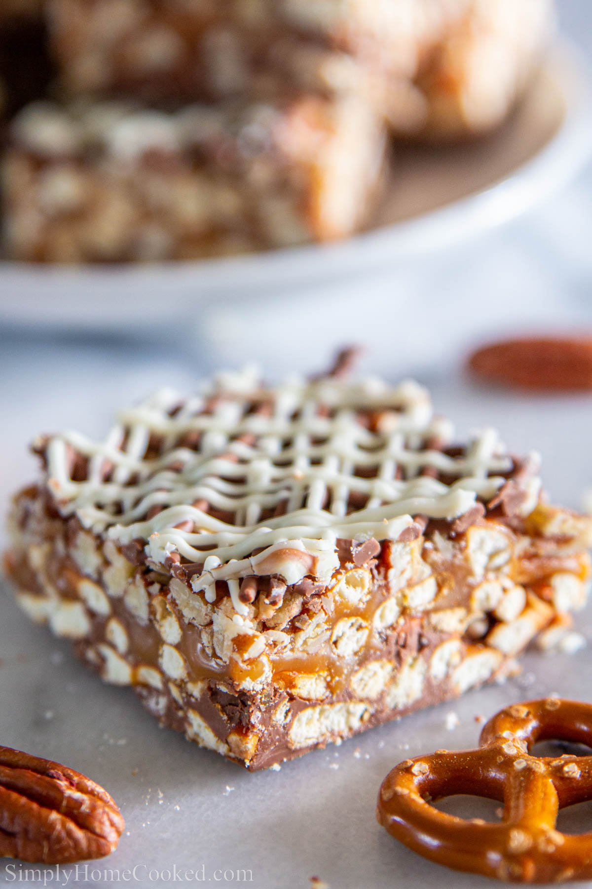 Chocolate Caramel Pretzel Bars with pretzels nearby.