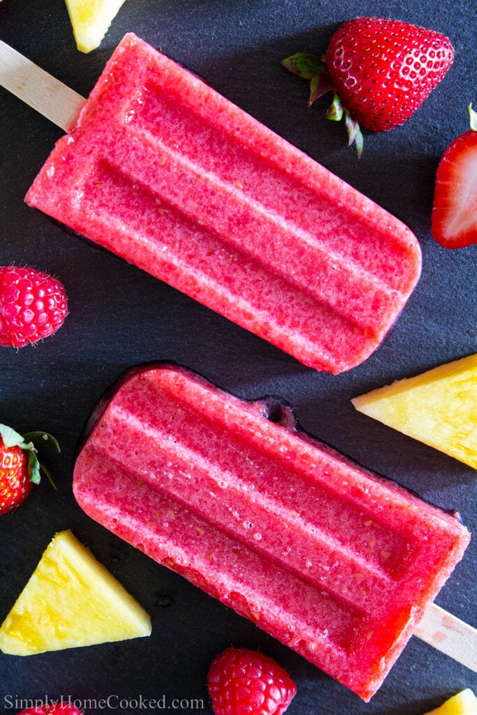Strawberry Popsicles with pineapple chunks, strawberries, and raspberries.