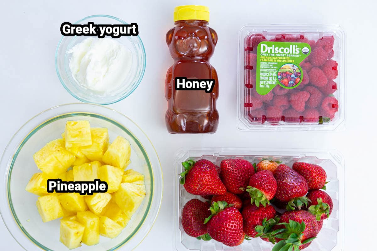 Strawberry Pineapple Fruit Popsicles are the perfect simple naturally sweetened frozen treat for hot summer days! An ideal healthy treat! #fruitpops #fruitpopsicle #summerpopsicles #strawberrypopsicles #popsiclerecipe Ingredients for Strawberry Popsicles: pineapple, Greek yogurt, honey, raspberries, and strawberries.