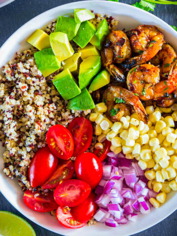Shrimp Quinoa Bowl with tri-color quinoa, shrimp, avocado, tomatoes, red onion, and corn.