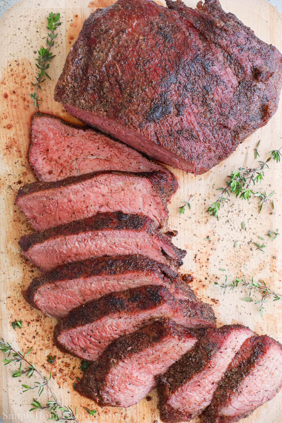 Smoked Tri Tip on a cutting board and half sliced.