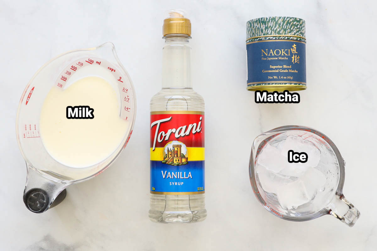 Ingredients for Iced Matcha Latte: milk, vanilla syrup, matcha powder, and ice.