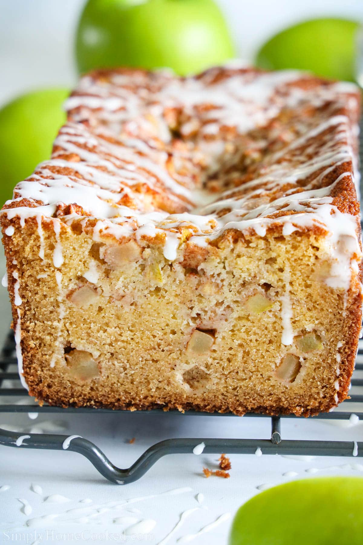 This Apple Fritter Bread is moist & delicious. Enjoy a slice of this sweet, apple flavored bread that has the texture of the best pound cake. #applefritterbread #applefritterbreadrecipe #homemadeapplefritterbread #bestapplefritterbread Apple Fritter Bread on a wire cooling rack.