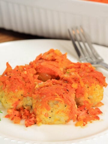 Lazy Cabbage Rolls covered with sauteed onions and carrots on a plate with a fork.