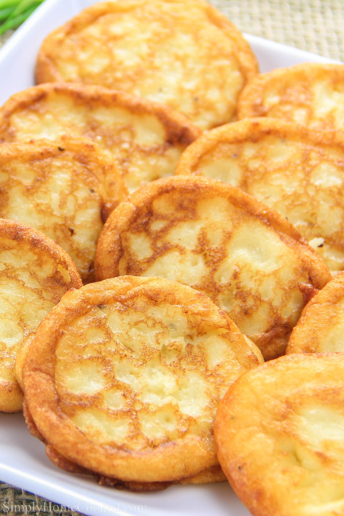 This mashed potato pancake recipe is simply the best way to use up those leftover mashed potatoes! #mashedpotatoes #potatopancakes #leftovers #savorypancakes Savory Mashed Potato Pancakes on a white plate.