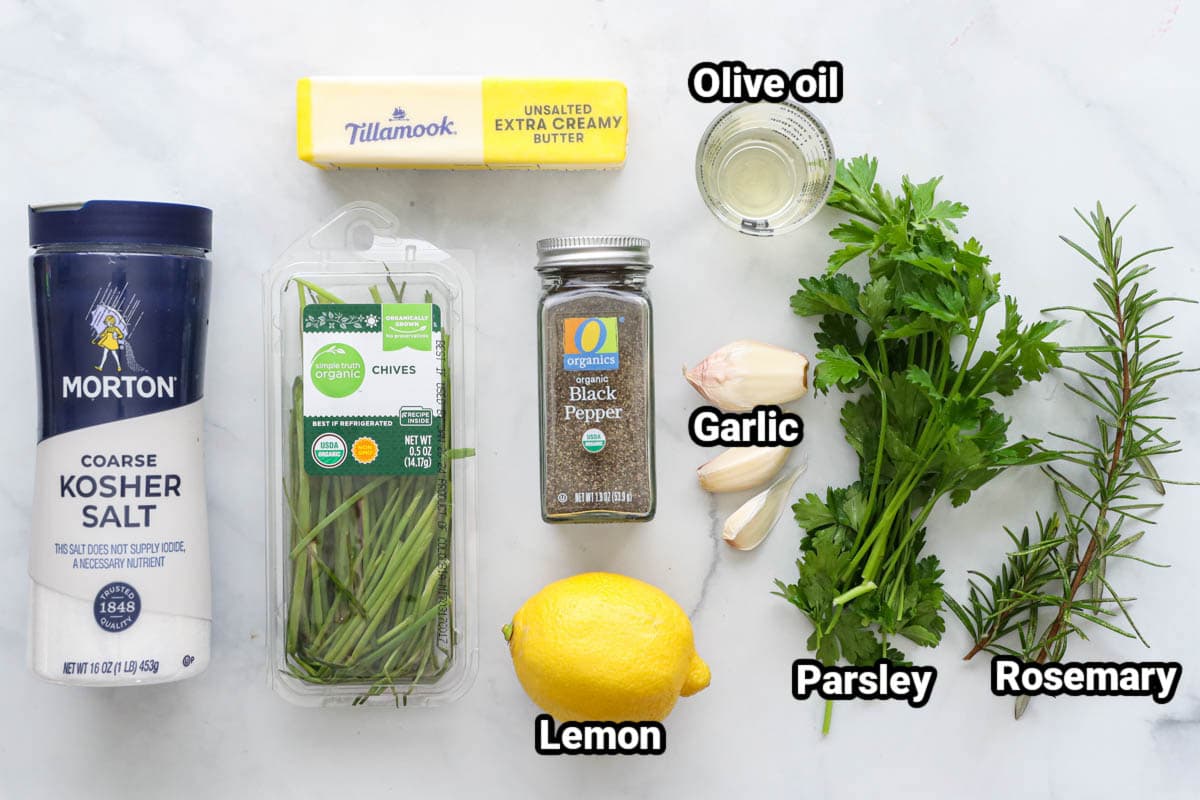 Ingredients for Compound Butter for Steak: kosher salt, chives, butter, pepper, live oil, garlic, lemon, parsley, and rosemary.