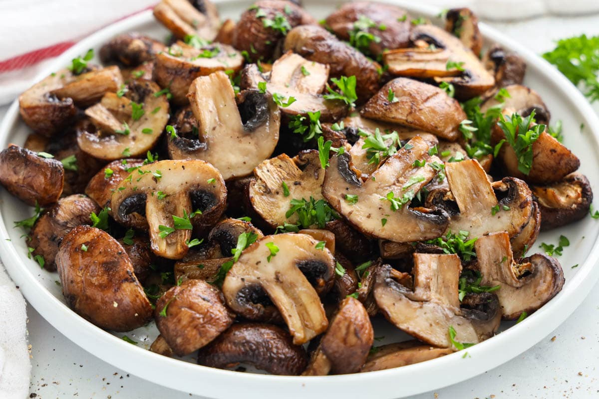 Air Fryer Mushrooms topped with parsley on a plate.
