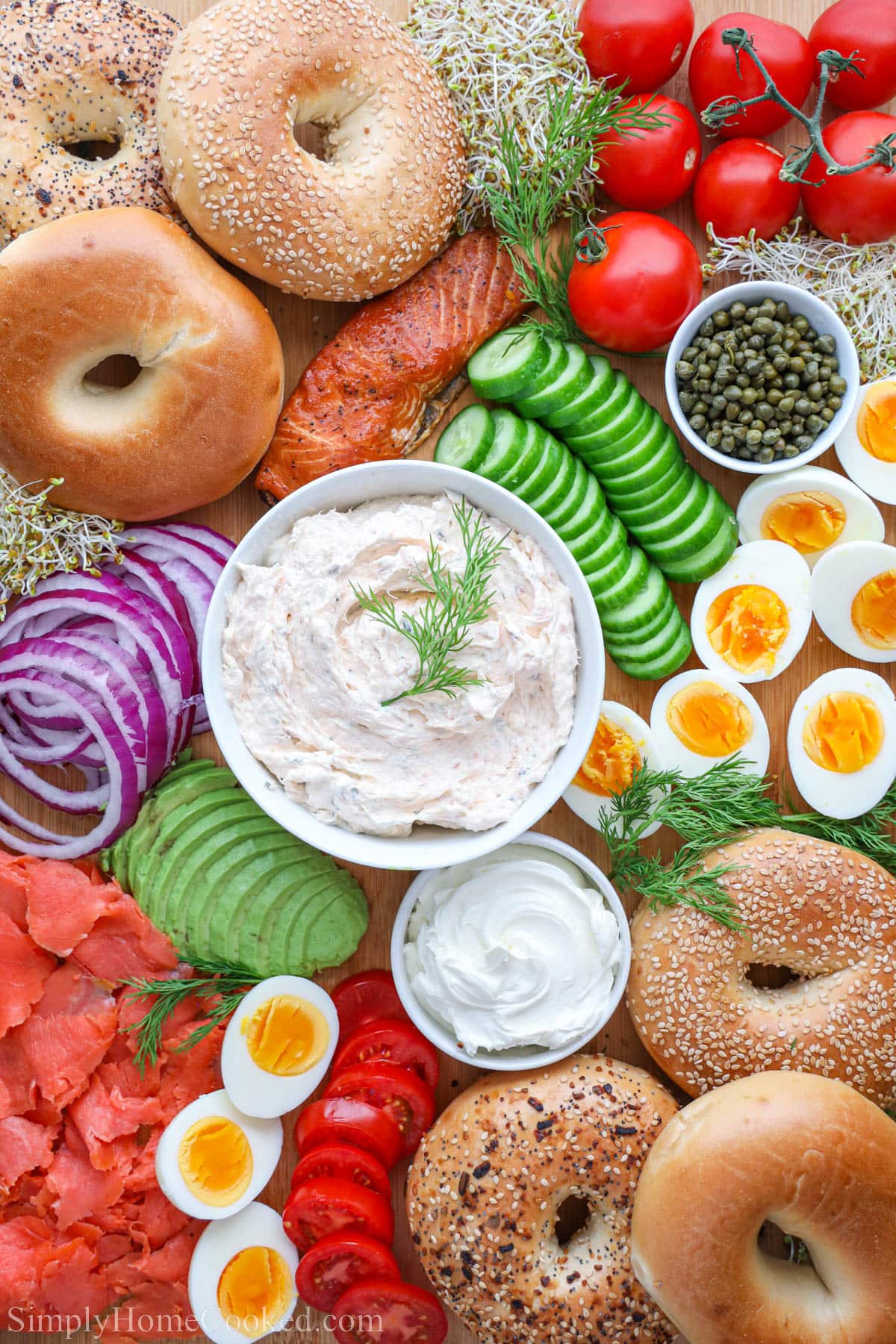 Bagel Board with smoked salmon spread, onions, cucumbers, lox, capers, cream cheese, hard boiled eggs, and tomatoes.