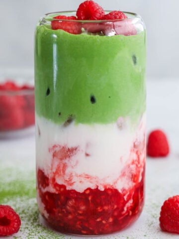 Raspberry Matcha Latte layers with raspberries, white chocolate milk, and matcha cold foam.