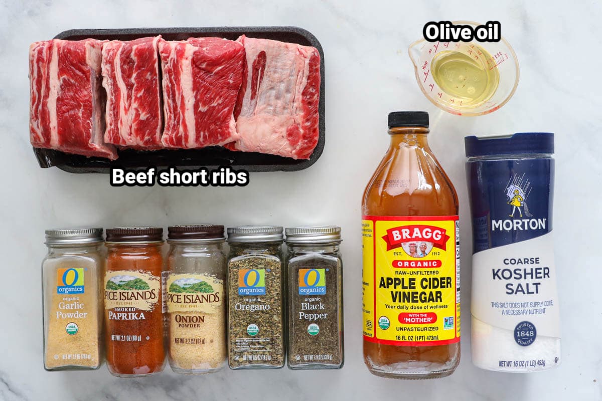 Ingredients for Smoked Beef Short Ribs: beef short ribs, olive oil, kosher salt, apple cider vinegar, black pepper, oregano, onion powder, smoked paprika, and garlic powder.