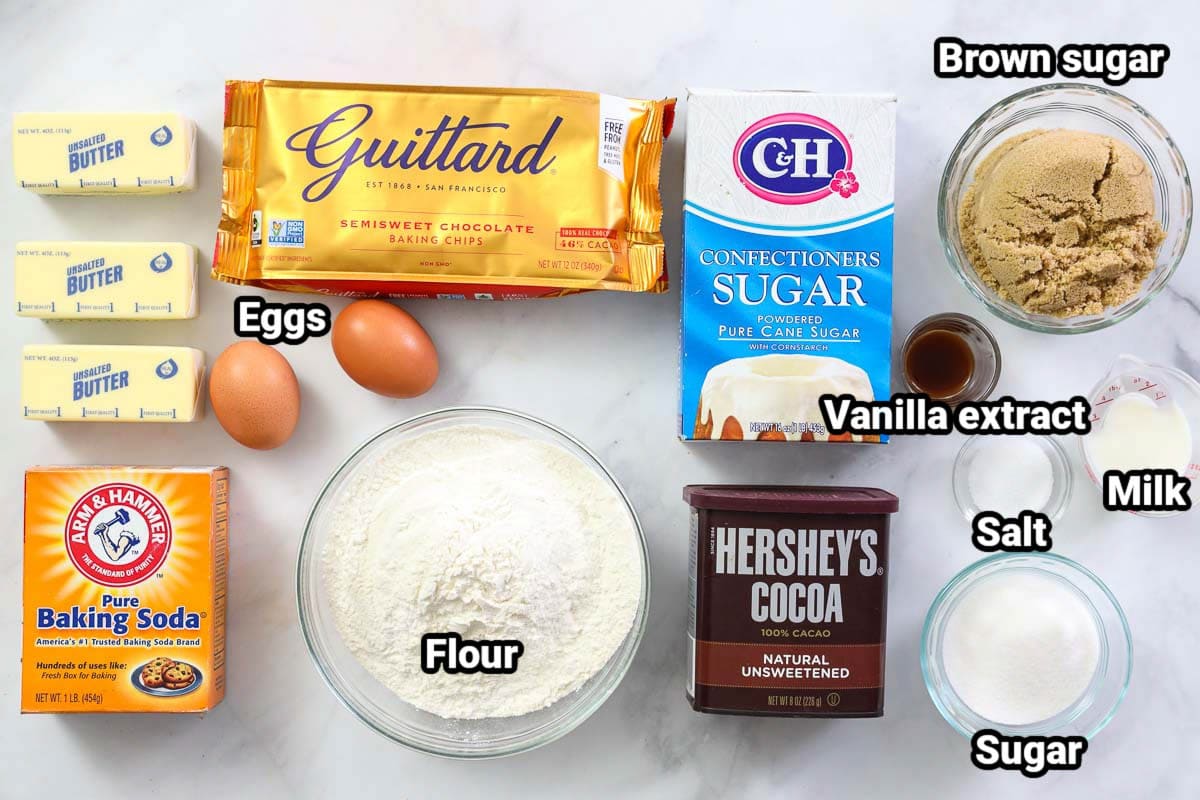 Ingredients for Cookie Cake: butter, eggs, baking soda, flour, sugar, powdered sugar, brown sugar, vanilla, salt, milk, and cocoa powder.