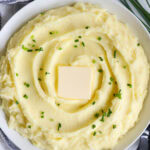 An overview of Yukon Gold Mashed Potatoes in a bowl topped with a pat of butter.