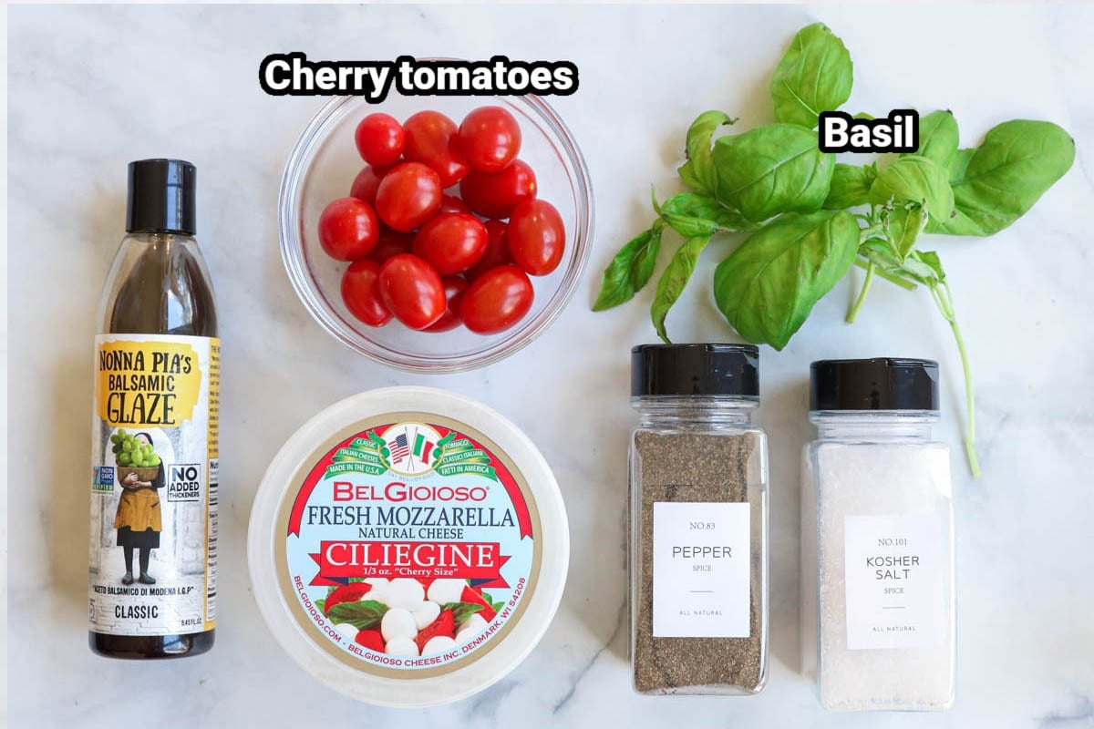 Ingredients for Caprese Skewers: cherry tomatoes, fresh mozzarella, basil, balsamic glaze, kosher salt, and black pepper.