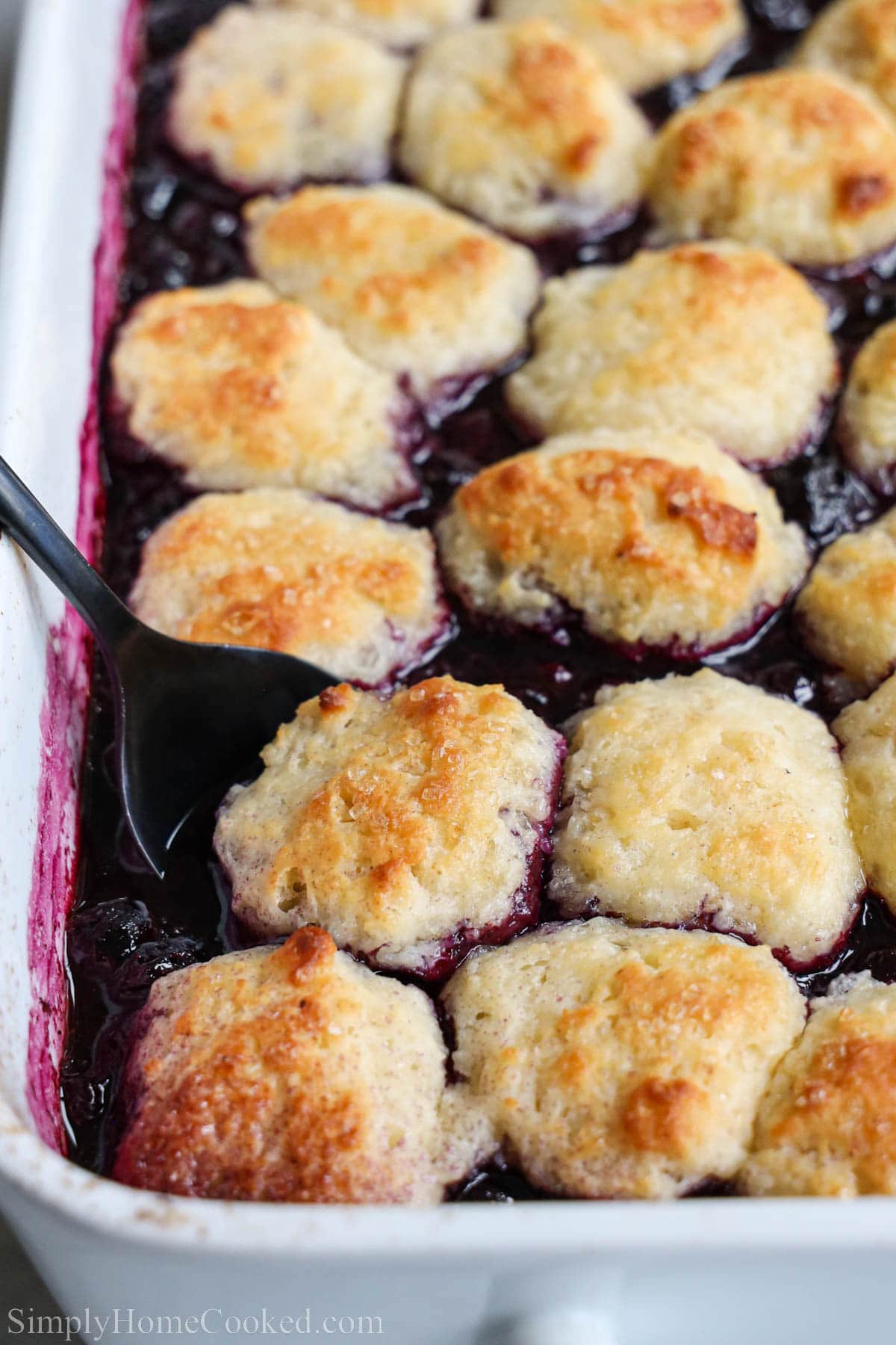 Blueberry Cobbler being scooped out of the baking dish.