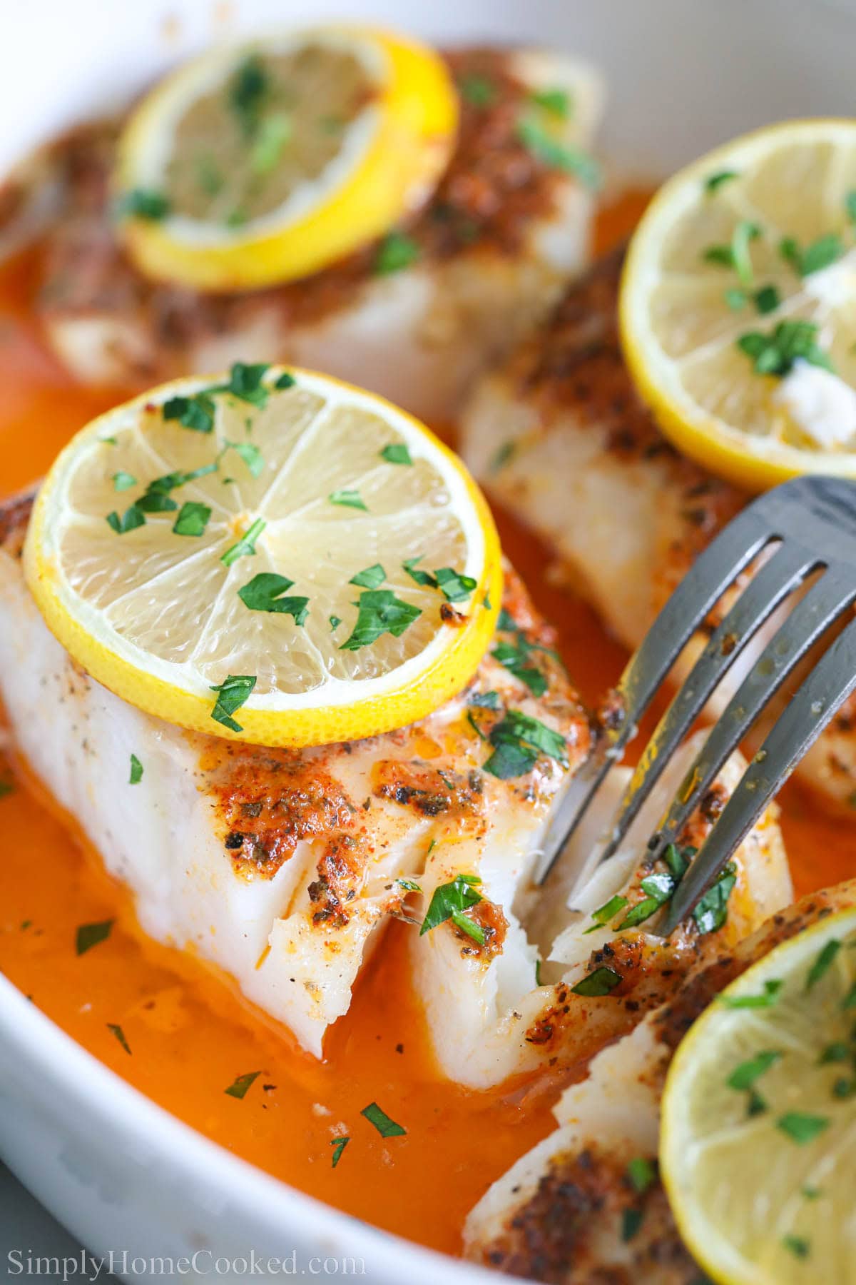 baked lemon butter cod in a white dish