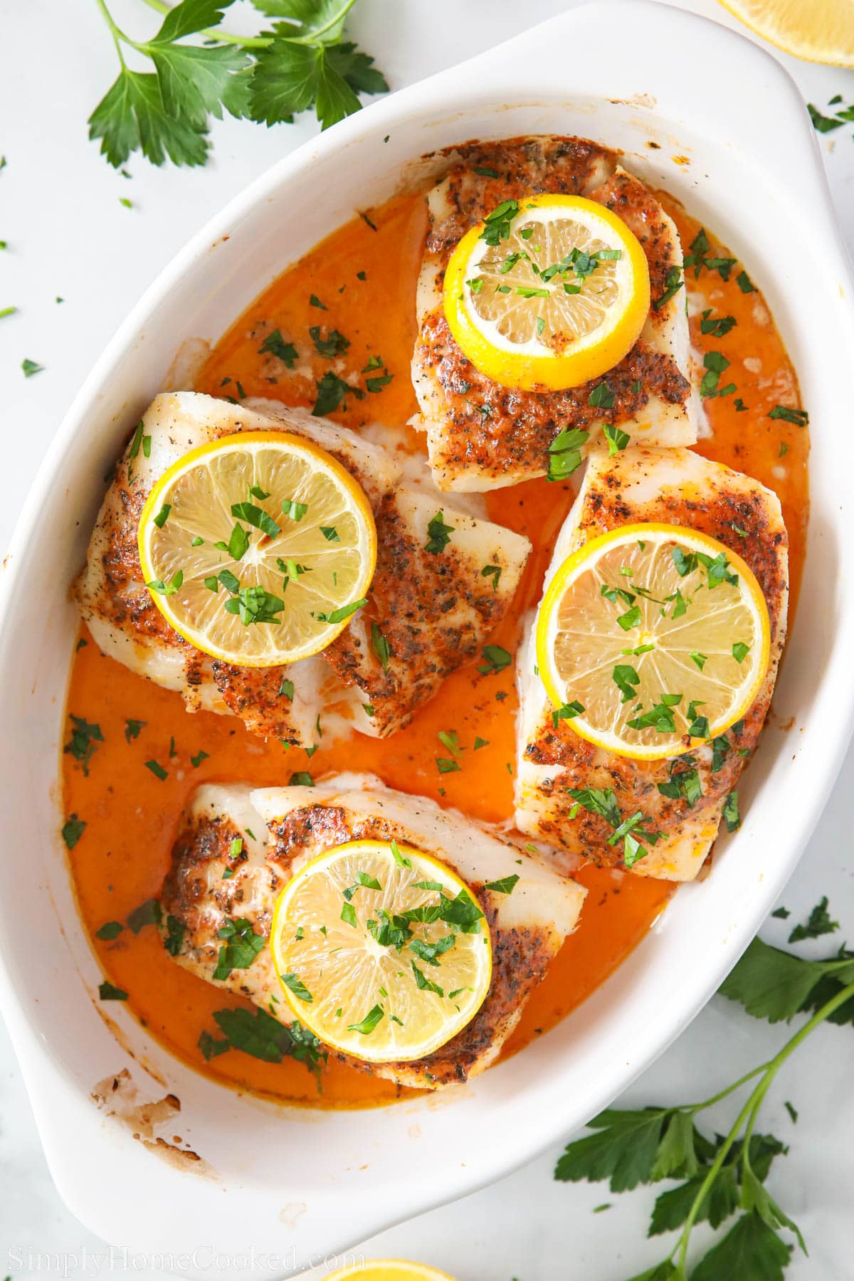 baked lemon butter cod in a white dish