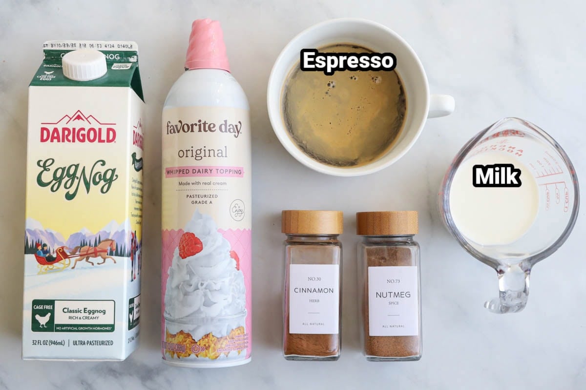 Ingredients for Eggnog Latte: eggnog, whipped cream espresso, milk, nutmeg, and cinnamon.