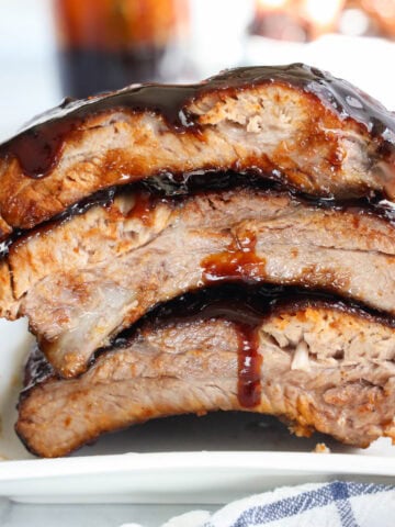 Close up of Oven Baked Ribs smothered in barbecue sauce.