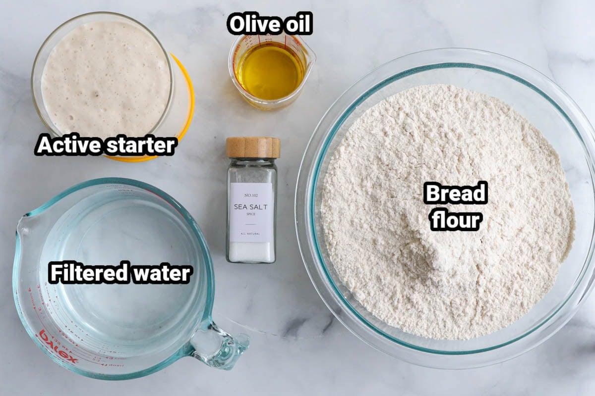 Ingredients for Sourdough Pizza Dough: active starter, olive oil, filtered water, olive oil, sea salt, and bread flour.