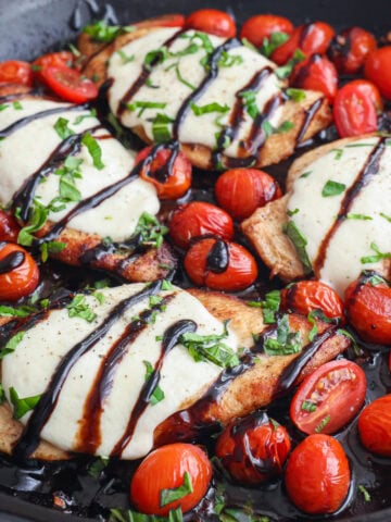 Chicken Caprese drizzled with balsamic. This Chicken Capese is scrumptious with juicy, buttery chicken, sweet cherry tomatoes, and creamy fresh mozzarella. This simple skillet meal is undeniably good. #chickencaprese #chickencapreserecipe #caprese #chickencapreserecipe