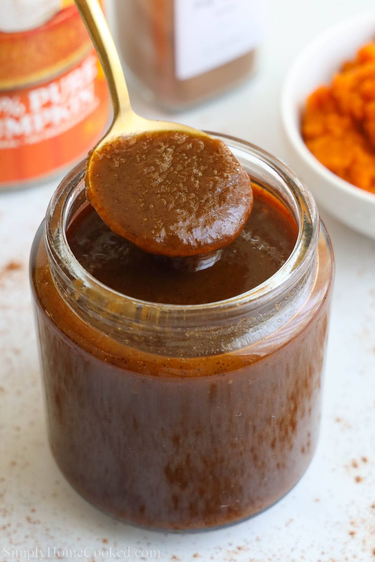 Pumpkin Spice Syrup in a jar with a spoon.